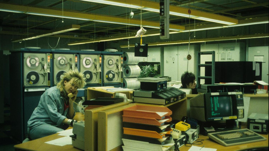 Okay — we all love a good retro haircut, but check out those old tape machines circa 1986! Payments data on magnetic tape was scanned in to a large computer.